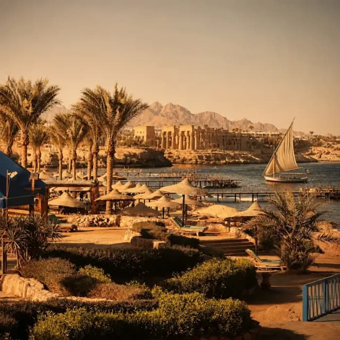 Felucca sailing past Nile temple landscape – Egypt cultural holiday